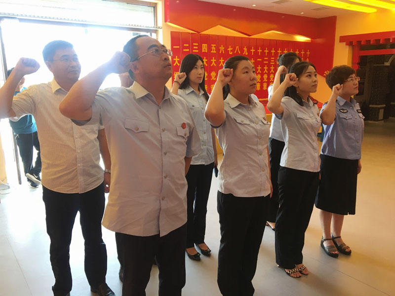 大洼法院干警面對黨旗進行重溫入黨誓詞活動。